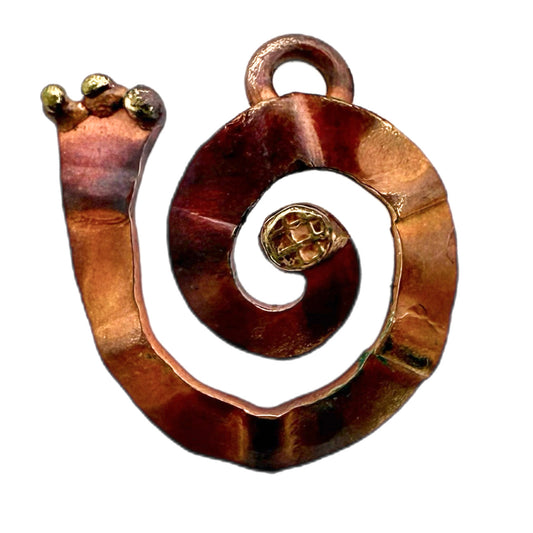 Left-facing rustic copper and brass spiral charm with torch-heated patina