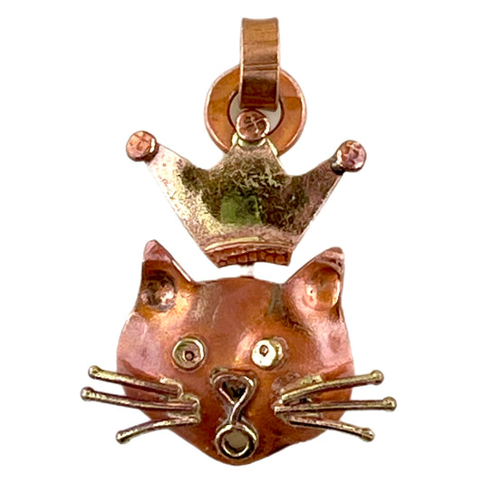 Small copper cat pendant with crown, brass accents, and red flame patina, handcrafted by Patricia Healey for feline-themed jewelry designs.