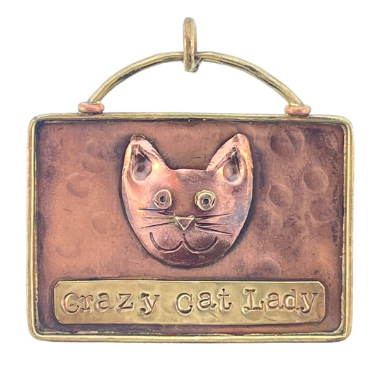 Handmade copper and brass cat pendant with antiqued flame patina and repoussé texture