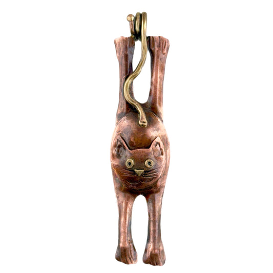 Stretching copper cat pendant with curling tail bail, brass accents, and red antiqued patina, handcrafted by Patricia Healey.
