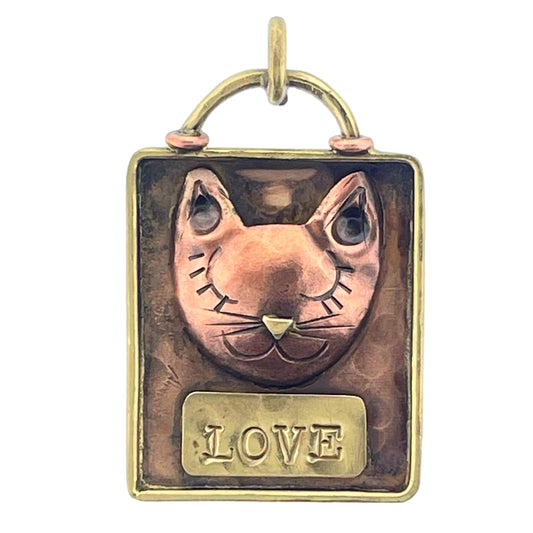 Copper cat pendant with hand-stamped details, brass accents, and a red flame patina, handcrafted by Patricia Healey as a playful expression of feline affection.
