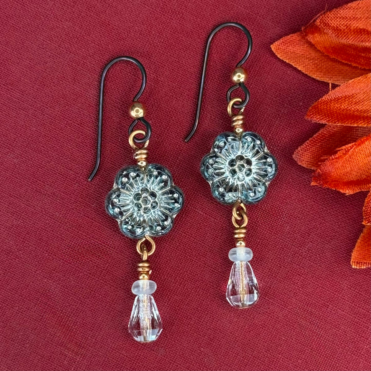 Turquoise blue glass daisy earrings with clear drop beads and copper wire details on niobium hooks
