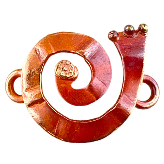 Right-facing copper and brass spiral jewelry link with soldered rings and flame-torched patina