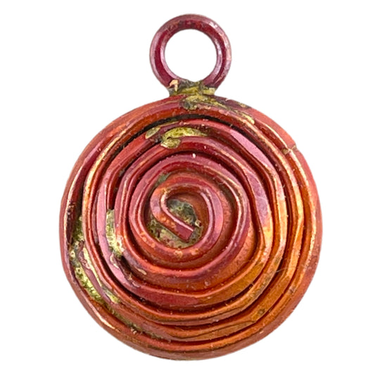 Reversible copper spiral charm showing concentric coils and linear texture, torch-touched patina