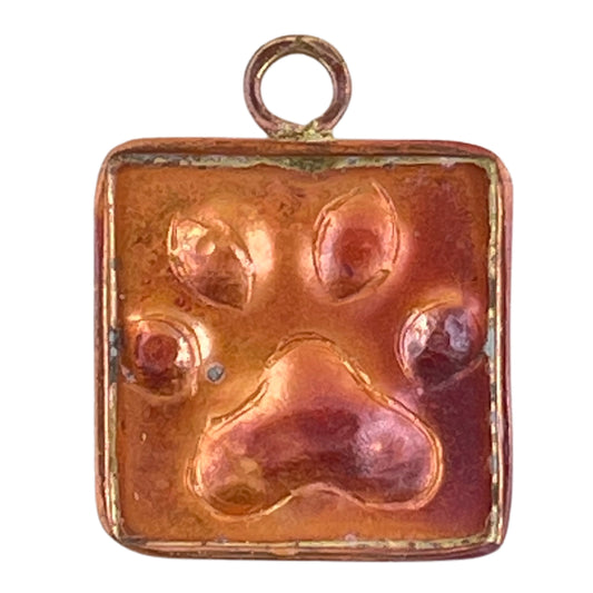 Small copper paw charm with red flame patina, handcrafted by Patricia Healey for pet lovers and artisan jewelry designs.