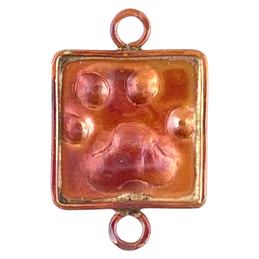 Copper paw charm with brass accents and red flame patina, handcrafted by Patricia Healey for earrings or pet-themed jewelry designs.