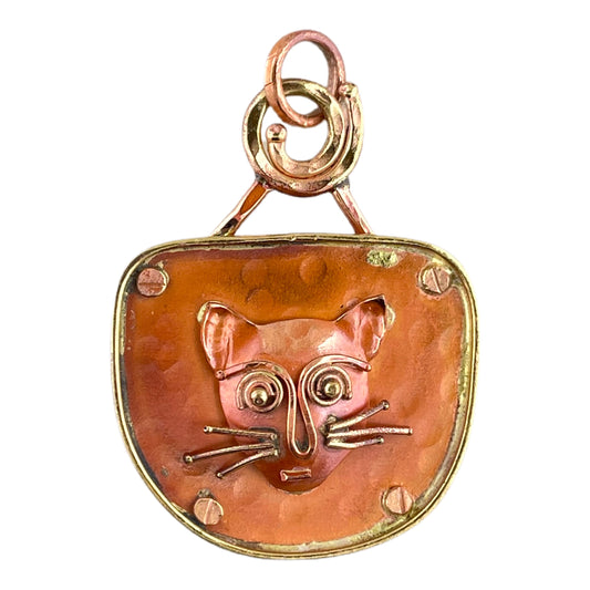 Handcrafted copper cat face pendant by Patricia Healey with brass whiskers, expressive eyes, and “love” stamped on the back.