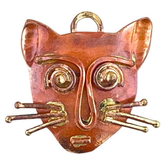 Small copper cat face charm with sculpted brass whiskers and red flame patina, handcrafted by Patricia Healey.