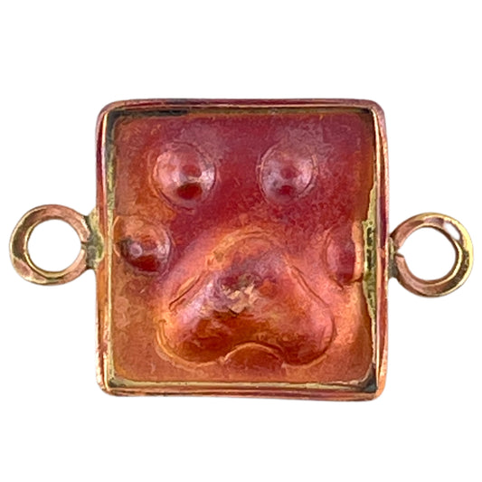 Copper paw print link with brass accents and red flame patina, handcrafted by Patricia Healey for use in pet-themed jewelry.