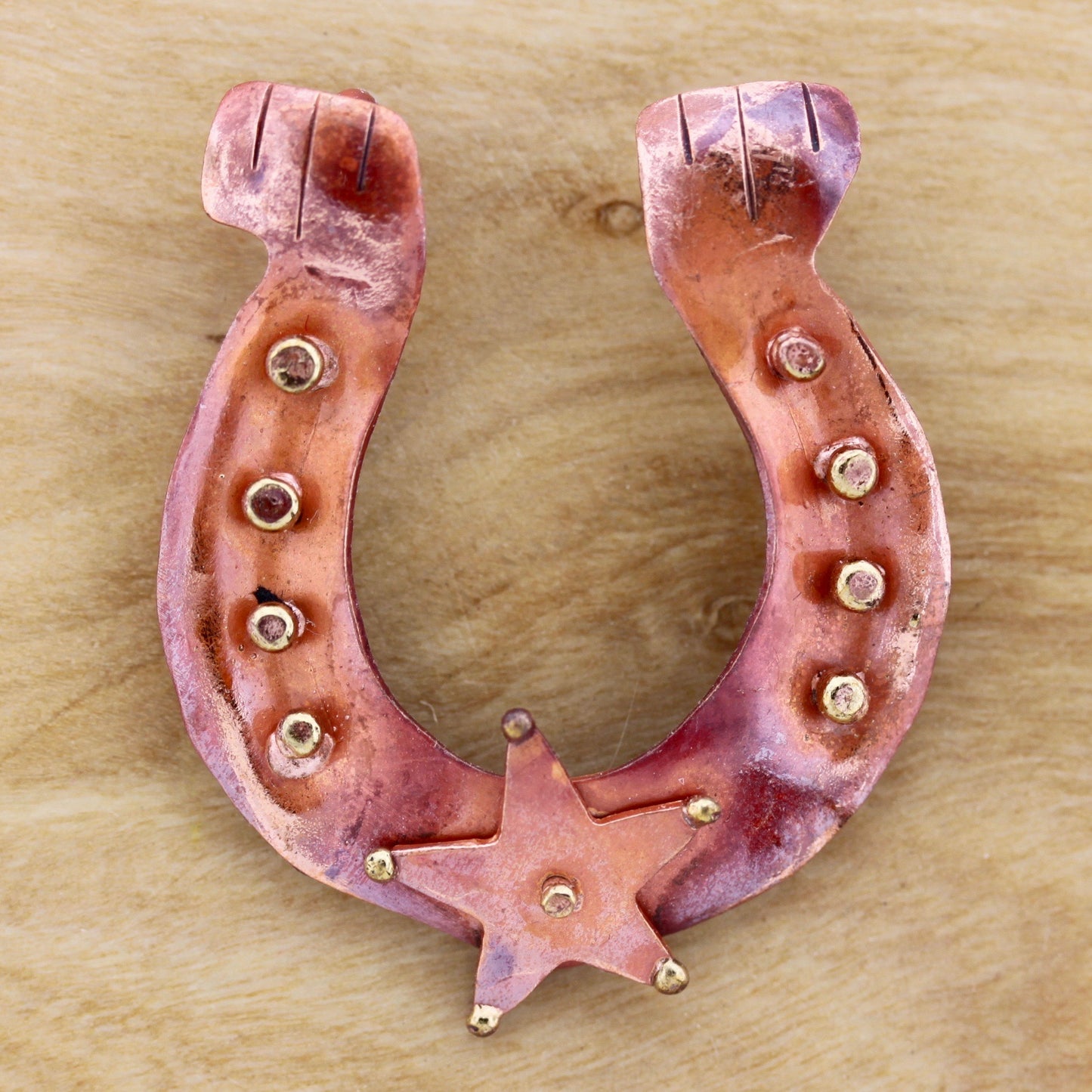 Handmade copper horseshoe pendant with brass star riveted at bottom, flame-torched finish