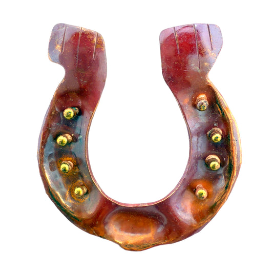 Handmade copper and brass horseshoe pendant with rivet details and flame-heated finish.