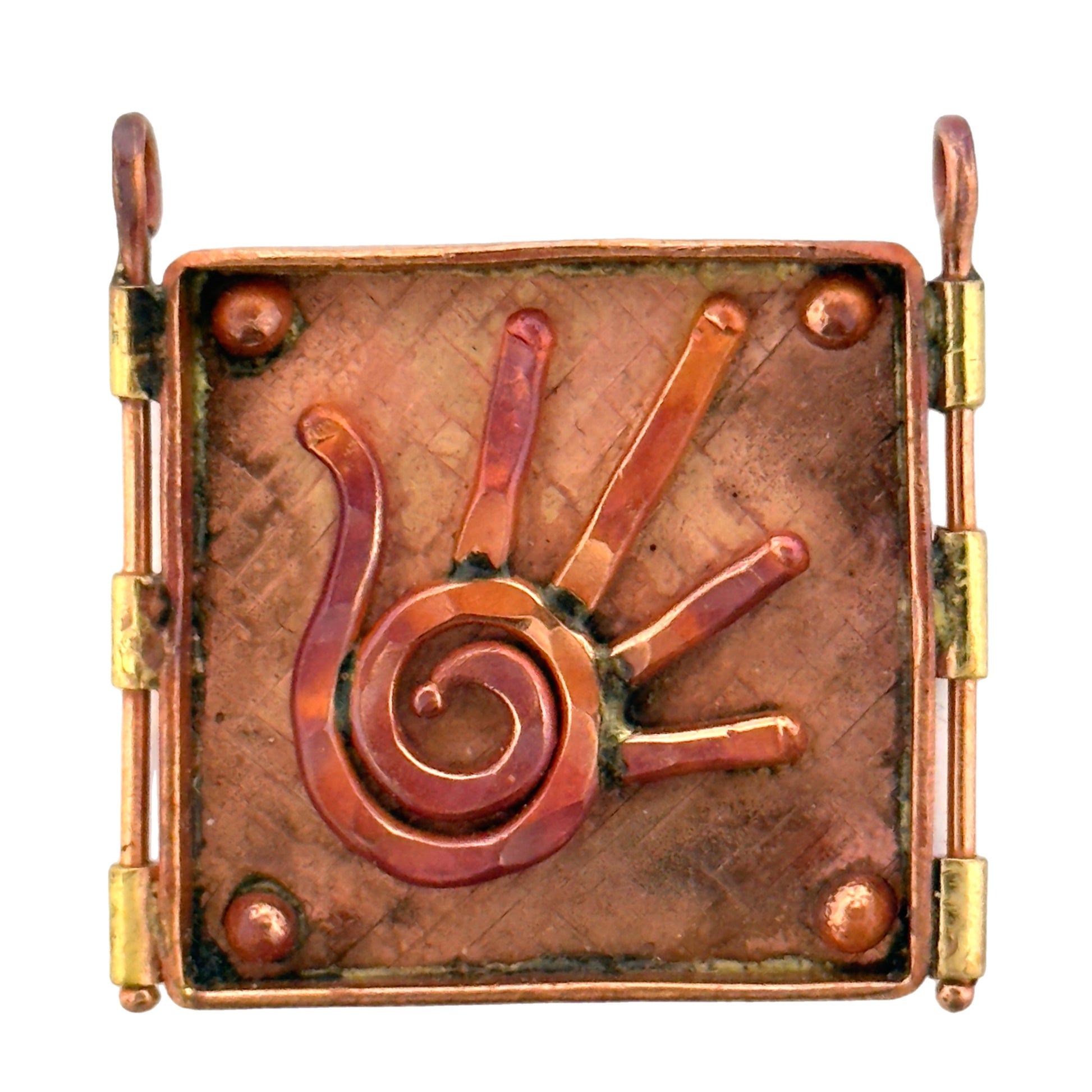 Handmade copper and brass pendant with raised spiral hand design, square shape, flame-heated finish, and textured background.