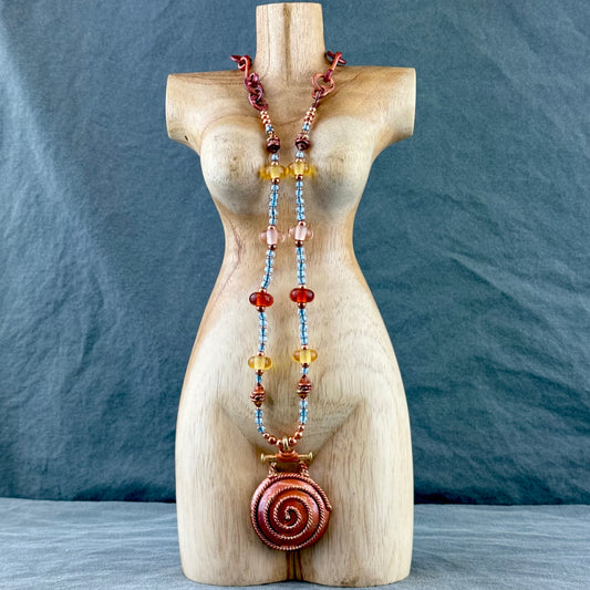 Handmade spiral copper pendant necklace with artisan glass beads and blue Japanese seed beads, handcrafted by Patricia Healey