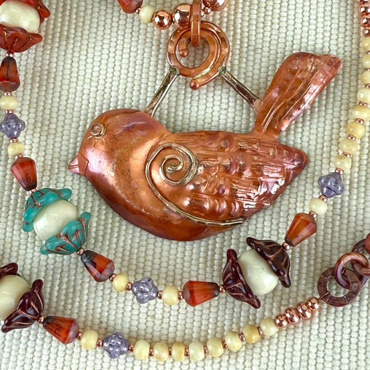 Copper bird pendant necklace with colorful Czech glass and bone beads, heart-shaped toggle clasp