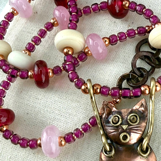 handmade copper cat necklace with brass details and pink artisan glass beads