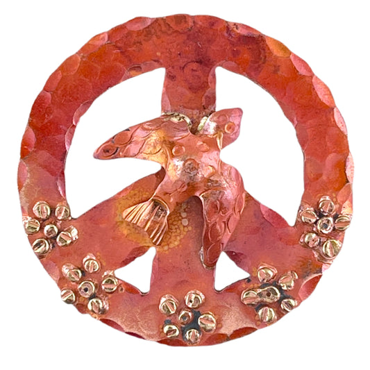 Handcrafted copper peace sign pendant with dove and flower details, flame-fired in red-orange tones with brass accents. Designed by Patricia Healey.
