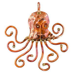 Artisan copper octopus pendant with swirling arms, repoussé texture, red flame patina, and brass detailing by Patricia Healey
