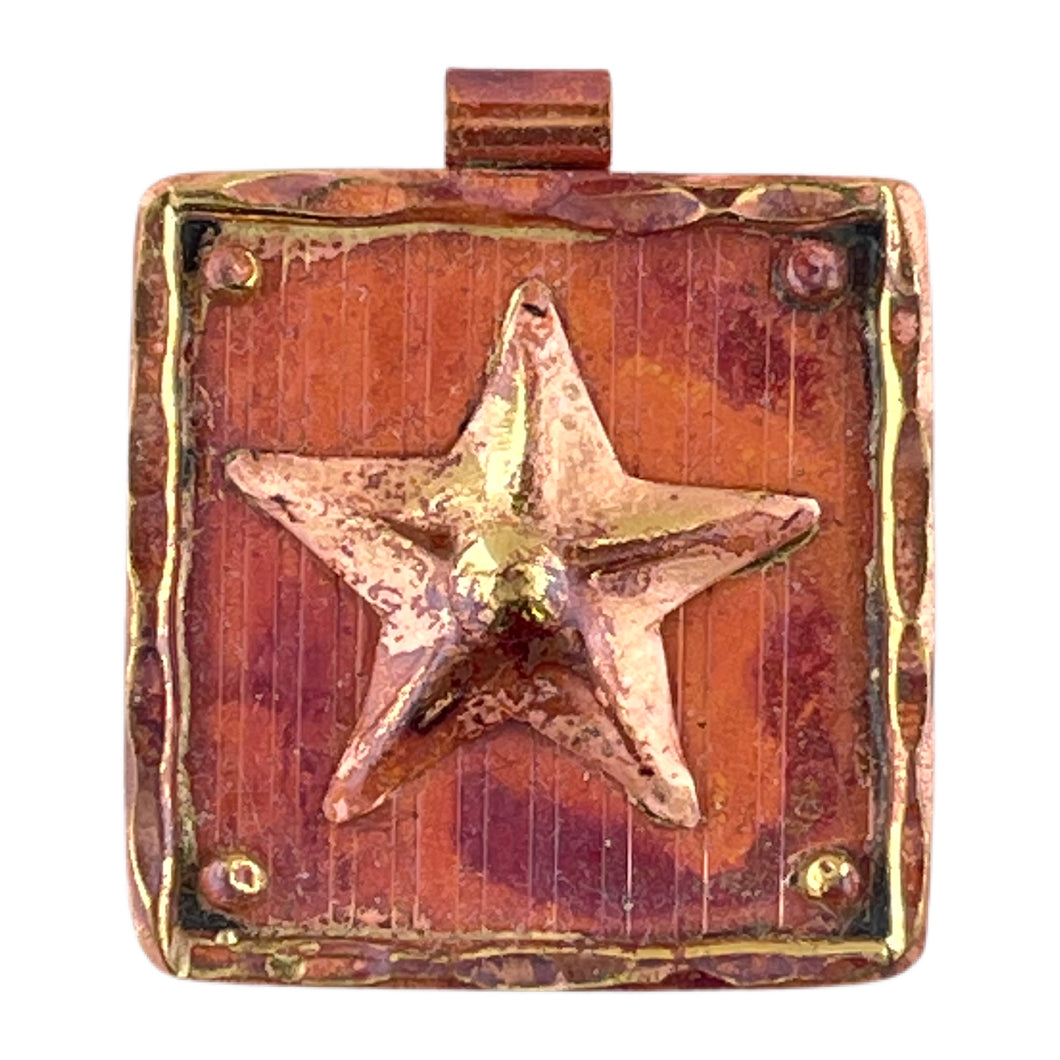 Handmade copper and brass star pendant with repoussé detail, hammered brass frame, and rich red-orange torch-fired patina by Patricia Healey