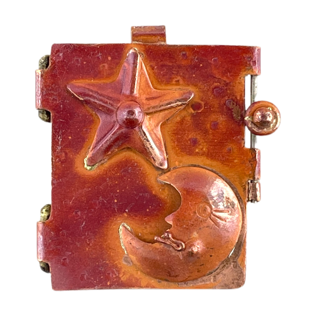 Copper celestial locket with moon and stars design, torch-fired red patina, repoussé relief, and brass accents