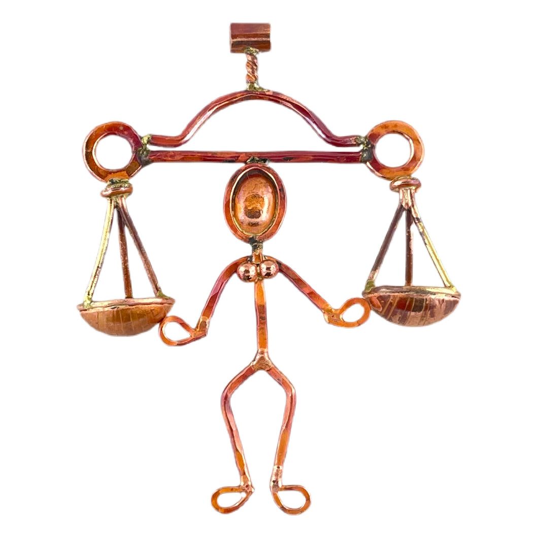 Handmade copper pendant with scales of justice and brass accents, symbolizing Libra, designed by Patricia Healey
