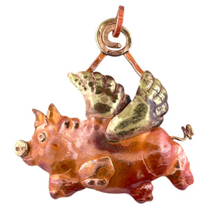 Handmade copper and brass flying pig pendant with outstretched wings and warm torch-fired patina