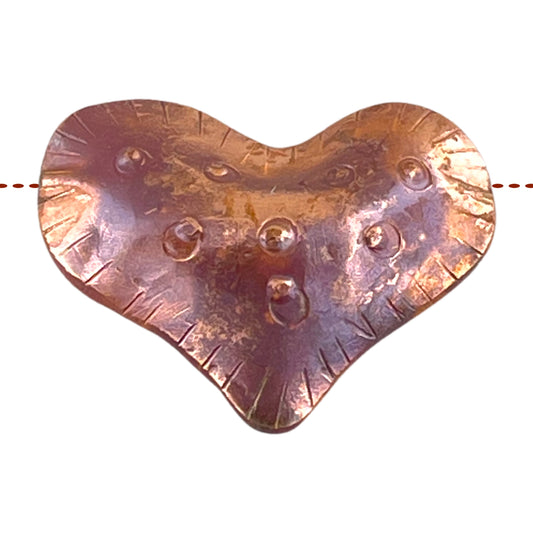 Large side-drilled puffy copper heart bead with red-orange flame patina and hand-stamped texture