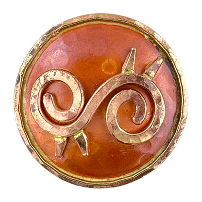 Copper Ahoden symbol pendant with brass accents, hammered texture, and flame-fired patina in red and orange tones. Designed by Patricia Healey.