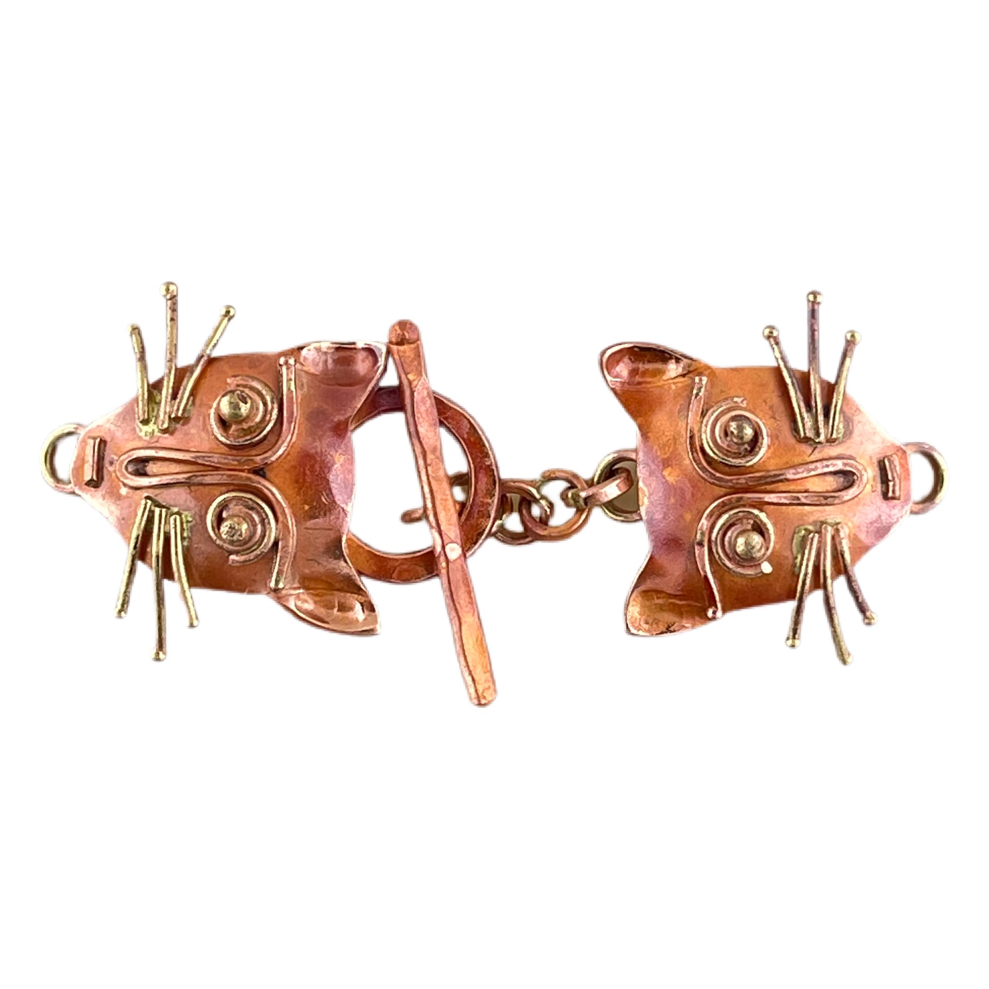 Handcrafted copper toggle clasp with sculpted cat face loop and coordinating bar, featuring brass details and a red flame patina by Patricia Healey.