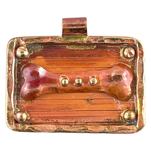Handcrafted copper dog bone pendant with brass frame and red flame patina, designed by Patricia Healey for playful, pet-inspired jewelry