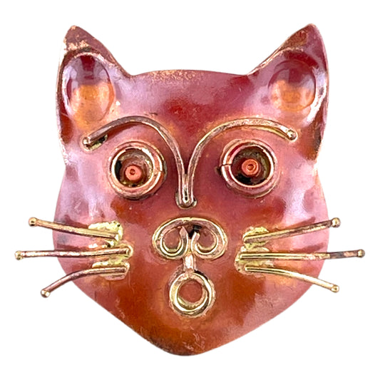 Handcrafted copper cat head pendant with wide eyes, sculpted brass whiskers, and red flame patina by Patricia Healey.