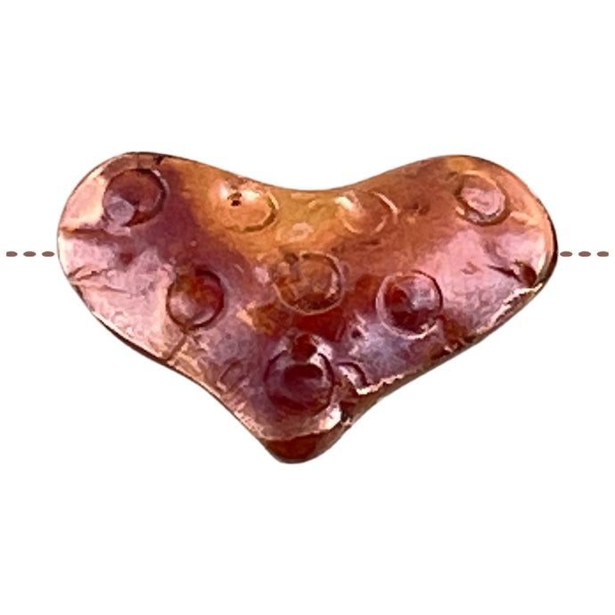 Side-drilled copper heart bead with red-orange flame patina and hand-stamped texture