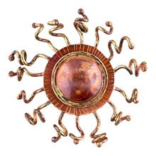 Handcrafted copper sunburst pendant with domed center, brass rays, and red-orange torch-fired patina by Patricia Healey