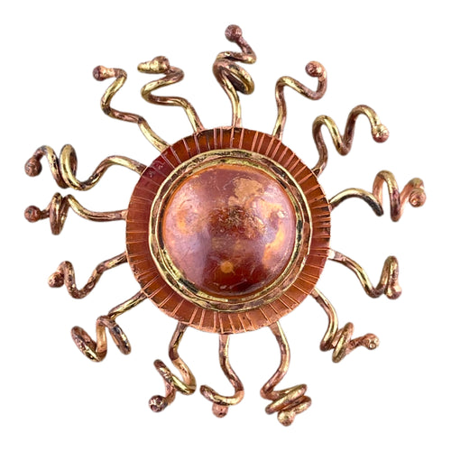 Handcrafted copper sunburst pendant with domed center, brass rays, and red-orange torch-fired patina by Patricia Healey