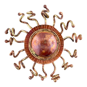 Handcrafted copper sunburst pendant with domed center, brass rays, and red-orange torch-fired patina by Patricia Healey