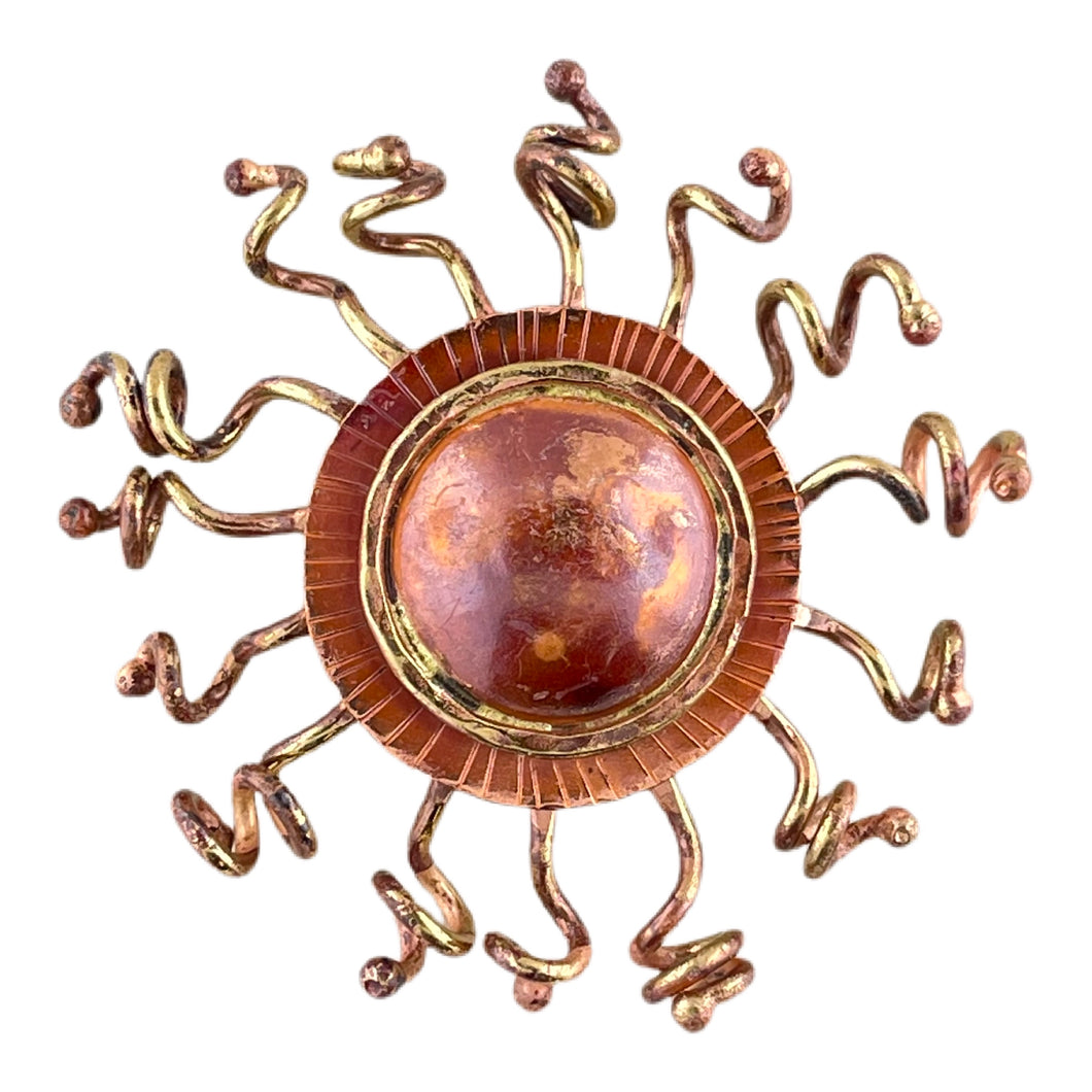 Handcrafted copper sunburst pendant with domed center, brass rays, and red-orange torch-fired patina by Patricia Healey
